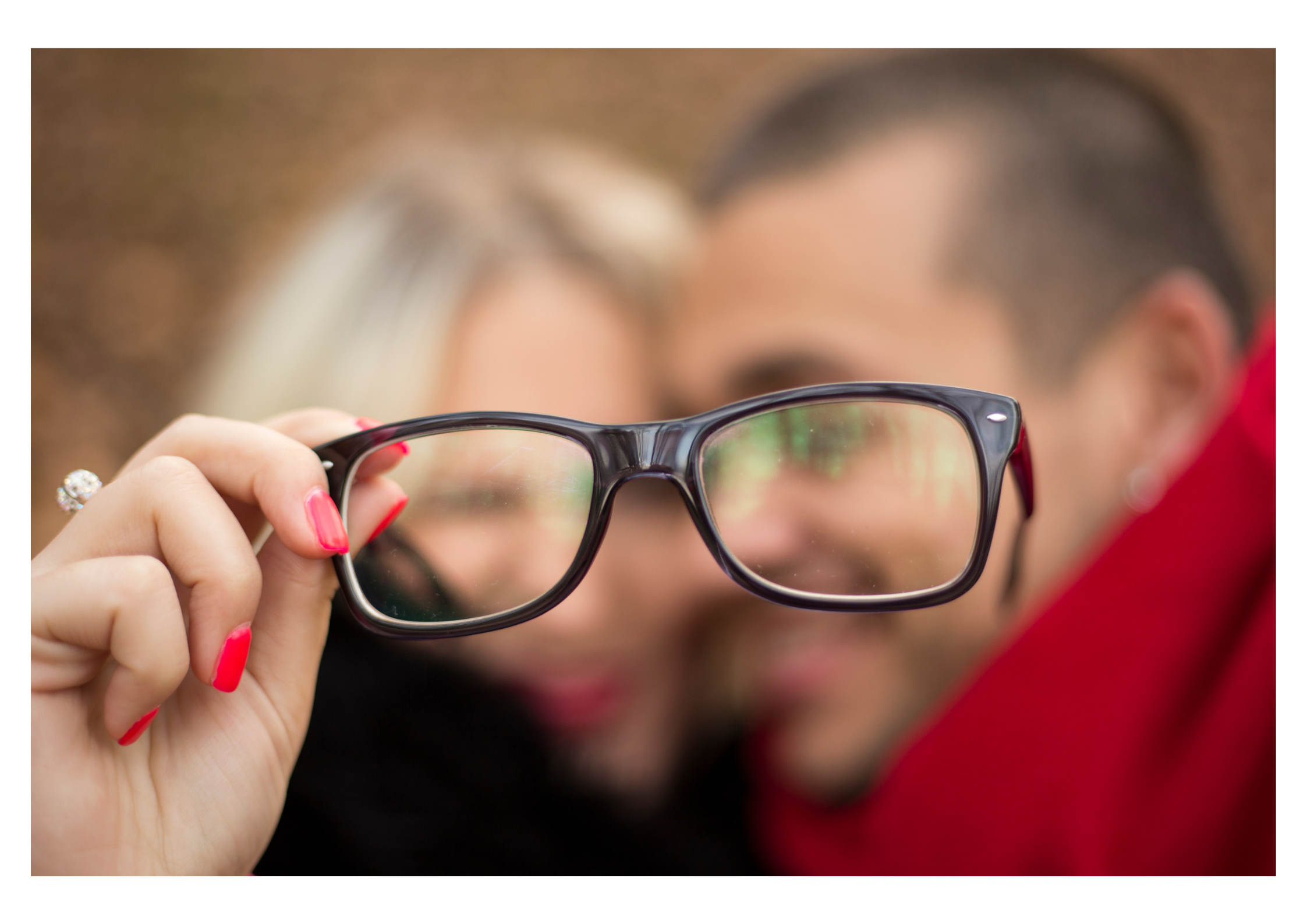 visage femme et homme floue et paire de lunette en premier plan